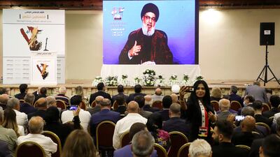 A woman takes a selfie as Hezbollah leader Hassan Nasrallah speaks through a screen in Beirut during an event held in solidarity with Palestinians. Reuters