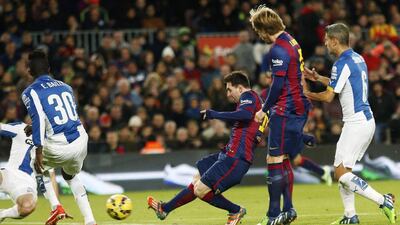Lionel Messi shoots and scores the second of his three goals against Espanyol on Sunday for Barcelona. Gustau Nacarino / Reuters