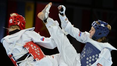 Russia's Anastasiia Baryshnikova (blue) fights against Slovenia's Nusa Rajher during their women's taekwondo quarter-final bout. Toshifumi Kitamura/AFP Photo