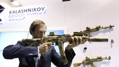 Russian trade and industry minister Denis Manturov aims a weapon during Idex 2015 in Abu Dhabi. Reuters
