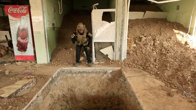 An Iraqi special forces soldier looks down the entrance of a tunnel used by ISIS fighters inside a restaurant in Bazwaya, east of Mosul. Reuters
