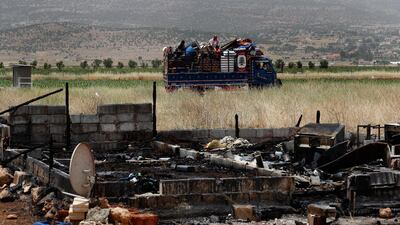 A Syrian family with their belongings evacuate a refugee camp on Sunday after a fight broke out last week between camp residents and Lebanese firefighters in Deir Al Ahmar. AP