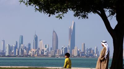 Kuwaitis walk along a beach in Kuwait City. AFP