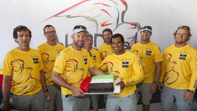 Abu Dhabi Ocean Racing's Ian Walker, skipper of the Azzam, presents ADOR team sailor Adil Khalid with a birthday cake. Ian Roman / Abu Dhabi Ocean Racing / October 7, 2014