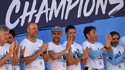Manchester City manager Pep Guardiola, centre, stands with his coaching staff during a stage presentation. AFP