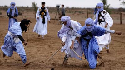 Nomads in traditional garb take part in a sand hockey match during the Nomads Festival, in Mhamid El Ghizlane in Morocco's southern Sahara desert. AFP