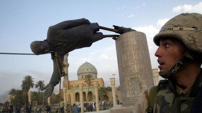 US marine corps assaultman Kirk Dalrymple watches as a statue of defeated Iraqi president Saddam Hussein falls in central Baghdad, in April 2003. Goran Tomasevic / Reuters