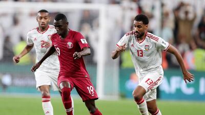 UAE's Ali Salmeen, left, and Khamis Esmail battle with Qatar's Almoez Ali in their Asian Cup semi-final.