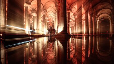 People are reflected in the waters of the Basilica Cistern while visiting the historic site in the Turkish city.