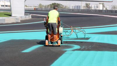 A painter uses a paint machine to get the Yas Marina Circuit race ready. Khushnum Bhandari / The National