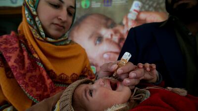 A health worker administers a polio vaccine to a child at a health center in Peshawar, northern Pakistan. AP