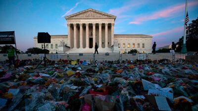 Flowers, candles, and signs are pictured at a makeshift memorial outside of the US Supreme Court as people pay their respects to Ruth Bader Ginsburg in Washington, DC on 19 September. Jose Luis Magana / AFP