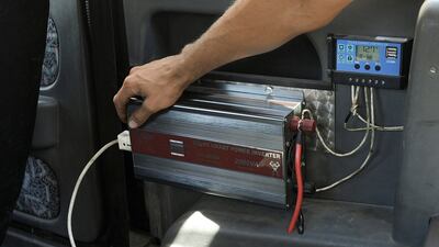 Mr Al Safadi switches on a solar smart power inverter inside the car.