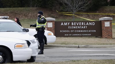 A police officer talks on the phone as he secures the site. Mykal McEldowney / The Indianapolis Star via AP