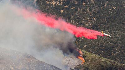 An air tanker drops retardant at a wildfire burns at a hillside in Yucaipa, California. AP Photo