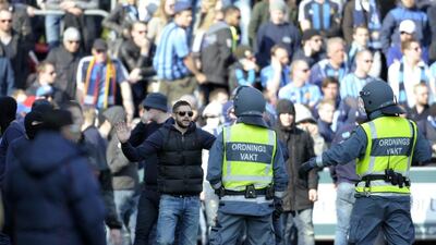 Security staff try to handle supporters of Stockholm soccer club Djurgarden that stormed the pitch during the Swedish league match between Helsingborgs IF and Djurgarden IF held at Olympia in Helsingborg, Sweden, on Sunday. The match was called off during the first half after a Djurgarden supporter died following clashes between fans in the southern city of Helsingborg. Police said the man was found "seriously injured" in central Helsingborg around 2.30pm and was taken to a hospital, where he later died. Local media said the 44-year-old Djurgarden supporter had been hit in the head by an object after rival fans started fighting before the game. Bjorn Lindgren / TT News Agency / AP / March 30, 2014