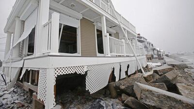 A damaged house sits along the coast in the Brant Rock section of Marshfield, Massachusetts, during the winter snowstorm. AP Photo/The Quincy Patriot Ledger, Greg Derr