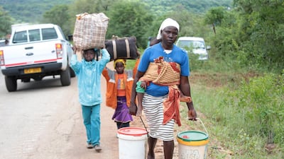 A woman and her children carry some of their belongings after their village was destroyed in Chimanimani, Zimbabwe. EPA
