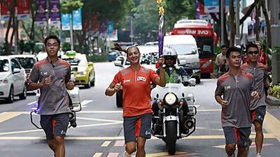 Russia's Yelena Isinbayeva, the double Olympic pole vault champion, carries the torch through downtown Singapore to mark the opening ceremony of the first ever Youth Olympic Games yesterday.