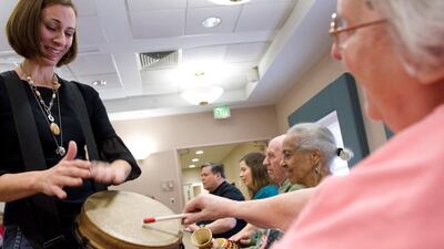 Music therapist Heather Davidson (left) plays a drum with Claire Diering (right) during a drum circle with patients with Alzheimer's disease at the Copper Ridge Care Centre in Sykesville, Maryland, on October 23, 2009. AFP