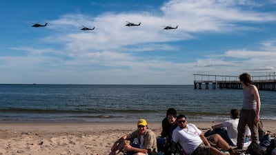 People enjoy a day at Coney Island as a line of helicopters fly by days before the Memorial Day weekend in New York City. Getty images