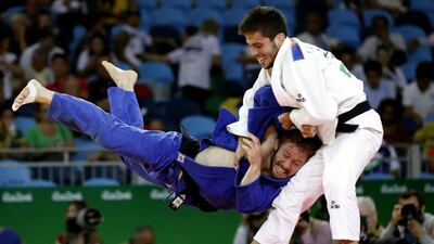 Spain’s Francisco Garrigos, in white, competes with Germany’s Tobias Englmaier during their 60kg judo contest. Jack Guez / AFP