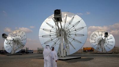 Men stand in front of solar panels at the Mohammed bin Rashid Al Maktoum Solar Park in Dubai. Reuters