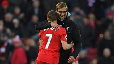 Liverpool's German manager Jurgen Klopp embraces midfielder James Milner after the English Premier League match against Burnley at Anfield in Liverpool, north west England on March 12, 2017. Liverpool won the game 2-1. Paul Ellis / AFP