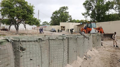 Workers clear the scene after a suicide car bomber drove into a checkpoint outside the port in Mogadishu. Reuters