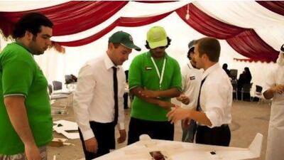 A Northrop Grumman employee demonstrates how to launch a model aeroplane before a student competition in Abu Dhabi.