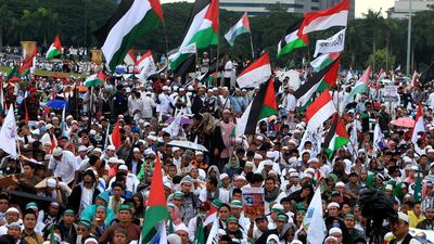 Indonesian muslim activists hold placards and wave Palestine national flags during a protest against US president Donald Trump's decision to recognise Jerusalem as the capital of Israel. Adi Weda / EPA