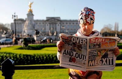Royal super fan John Loughery holds a copy of a British newspaper as he poses for the media outside of Buckingham Palace in London. AFP