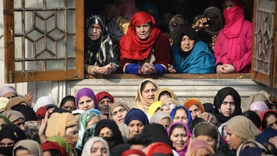 Kashmiri Muslims pray as a priest displays a relic at the shrine ceremony of Sheikh Abdul Qadir Geelani in Srinagar. AFP