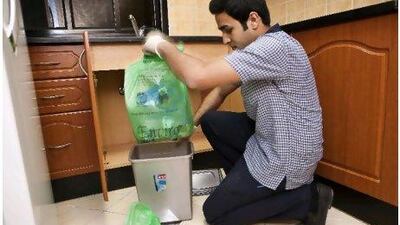 Hassan Naseer, a housekeeper at the Ramada Hotel in Ajman, separates waste to be used for compost in one of the room's kitchens as part of a major new trend in the hospitality sector.