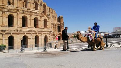 Fathi Bouzayan, 53, sits on his camel that usually gives rides to tourists outside El Jem amphitheatre, in the city of El Djem, Tunisia. Reuters