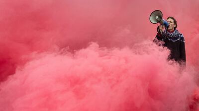A pro-Palestine protester is surrounded by smoke during a demonstration in Warsaw. AFP