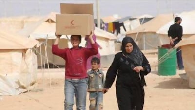 Syrian refugees, who fled the unrest in Syria, carry a box of food distributed by the United Arab Emirates Red Crescent ahead of Eid al-Adha (Feast of Sacrifice) at the Al Zaatri refugee camp in the Jordanian city of Mafraq, near the border with Syria. Reuters / Majed Jaber