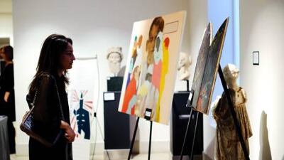 Guests view contemporary Pakistani art on display at a charity auction held in London this week. Matt Crossick for The National