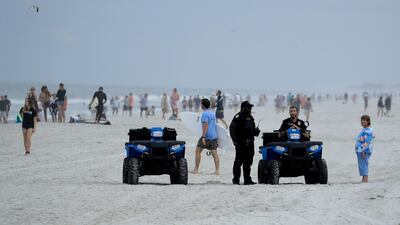Police are seen speaking to people at the beach in Jacksonville Beach, Florida. Getty Images / AFP