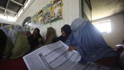 A woman reviews copies of ballot papers during an election awareness programme on the outskirts of Kabul.