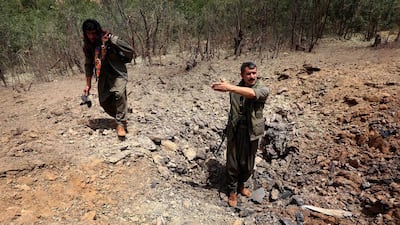 Members of the PKK inspect a crater reportedly caused by an air strikes by Turkish warplanes in 2015. Turkey continues to strike the region today. AFP