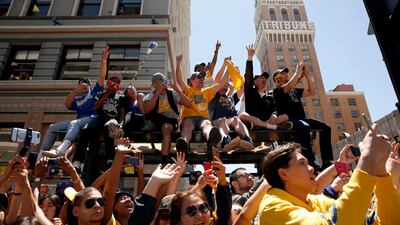 Fans cheer during the championship victory parade in downtown Oakland. The Warriors have won three of the last four NBA Championships, after a 40 year spell with no success. Cary Edmondson / Reuters