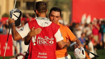 Rickie Fowler celebrates victory with caddie Joe Skovron on the 18th green. Andrew Redington / Getty Images