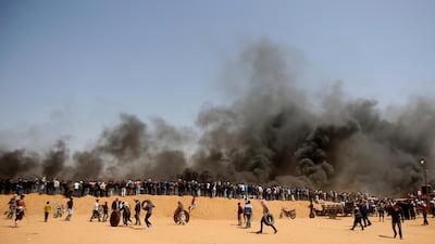 Palestinian protesters stand on sands hill. Adel Hana / AP Photo