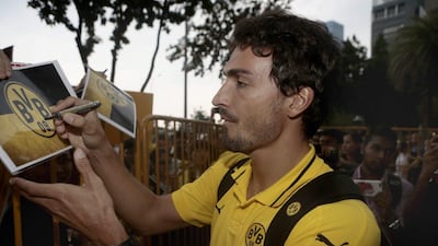 Mats Hummels signs autographs for fans as Borussia Dortmund arrive at the Fullerton Hotel in Singapore Wallace Woon / AFP / July 8, 2015