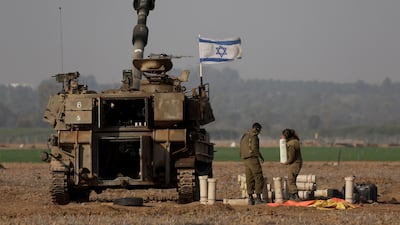 Israeli troops stand next to a tank amid ongoing battles with Hamas in Gaza. AFP