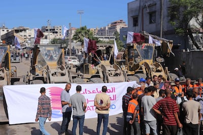 Palestinians gather as Gaza Municipality staff prepare to deploy bulldozers to clear rubble from main streets in Gaza city. AFP
