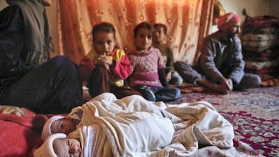 A mother sits with her two malnourished toddlers in Eastern Ghouta. AFP PHOTO / Amer ALMOHIBANY