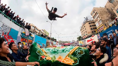 A young protester is blanket-tossed into the air by fellow demonstrators in Tahrir Square. AFP