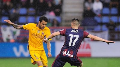 Barcelona defender Dani Alves, left, vies with Eibar’s forward David Junca. Ander Gillenea / AFP